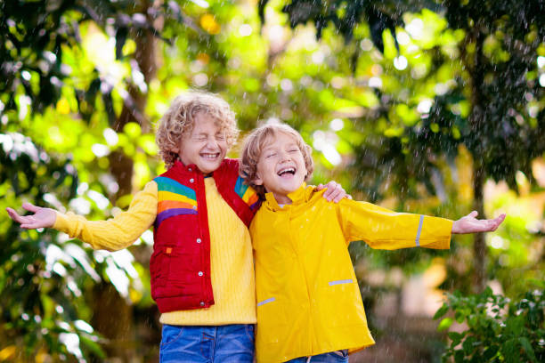 istock Child playing in autumn rain. Kid with umbrella. 1332880180