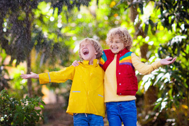 istock Child playing in autumn rain. Kid with umbrella. 1332880225