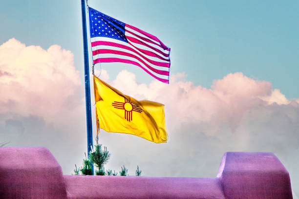ピンクのアドビの壁の上から輝くアメリカとニューメキシコ州の旗 - new mexico flag ストックフォトと画像