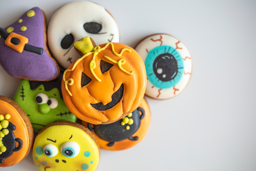 Delicious halloween party cookies. Top view. Halloween Gingerbread Cookies - pumpkin, ghosts, witch hat, spiderweb on halloween background. Top view.