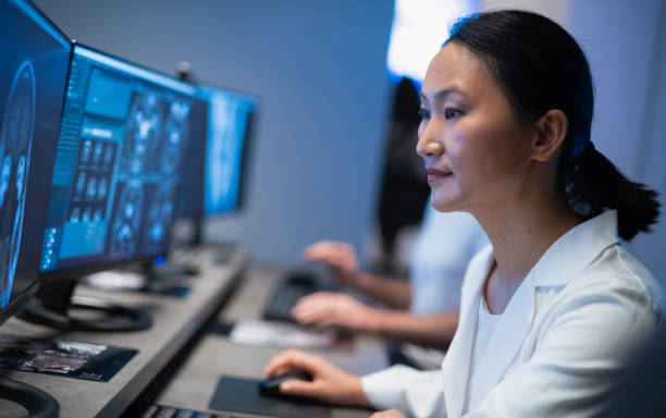 medici che lavorano con il computer e analizzano le scansioni mediche - radiologist foto e immagini stock