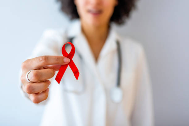 Symbol of awareness AID, HIV red ribbon. Symbol of awareness, charity, support in disease, illness. Medical health care, help and hope. Sign of healthcare medicine campaign holding in female doctor. hiv stock pictures, royalty-free photos & images