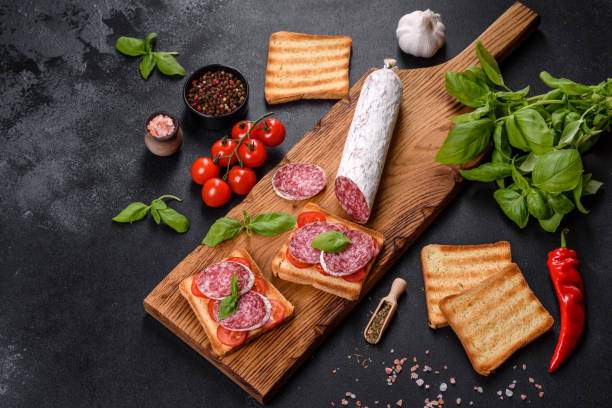 istock Spanish dried sausage salami on a dark concrete background 1332888568