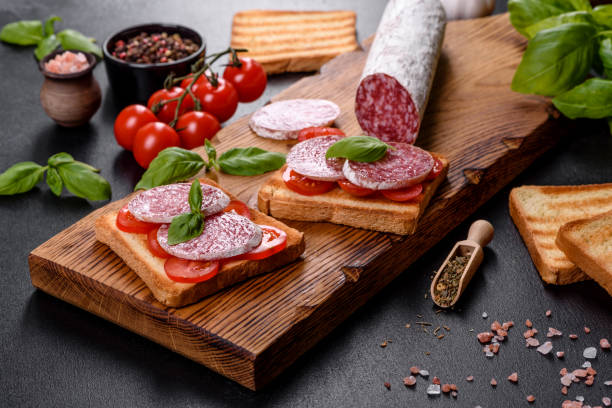 istock Spanish dried sausage salami on a dark concrete background 1332888611