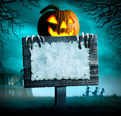 A skeleton peeks out from behind an old weathered sign in front of an old haunted house. Three trick or treating children walk away from the house in the background.