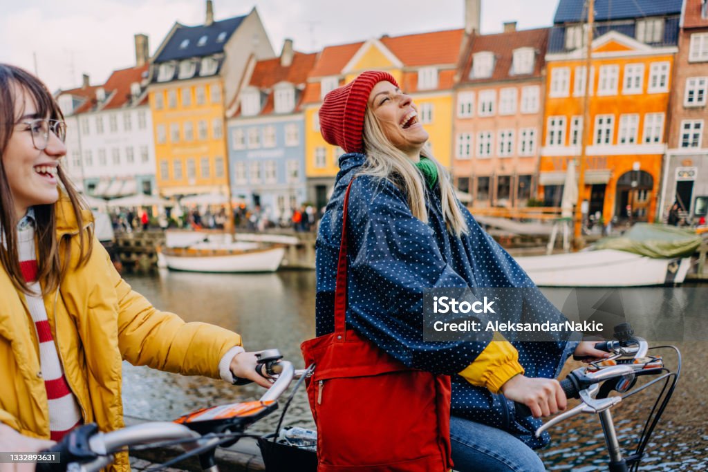 City getaway with my sister Photo of two young women riding bikes and having fun while discovering the new city together. Copenhagen Stock Photo