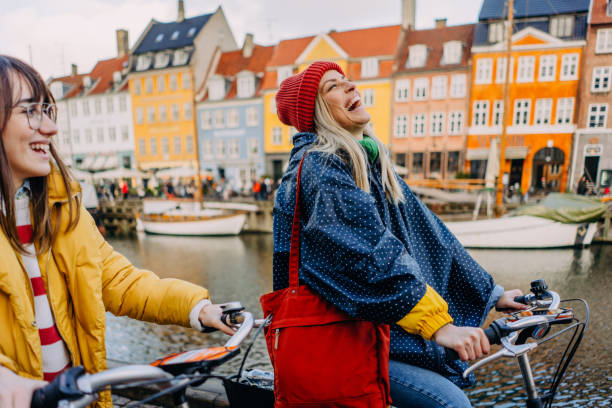 City getaway with my sister Photo of two young women riding bikes and having fun while discovering the new city together. copenhagen photos stock pictures, royalty-free photos & images