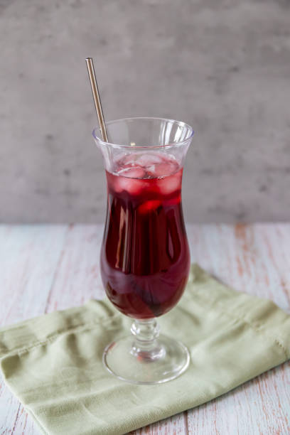 istock Cold Karkade tea with ice cubes in a long drink glass 1332894321
