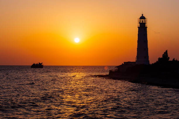 istock Lighthouse on the sea coast at sunset 1332894910