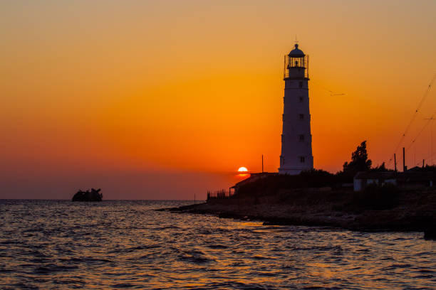 istock Lighthouse on the sea coast at sunset 1332894979