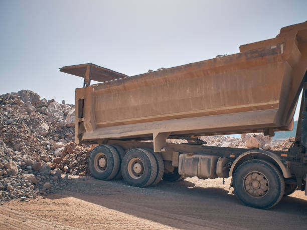 istock Dump truck unloads soil from truck back 1332897836