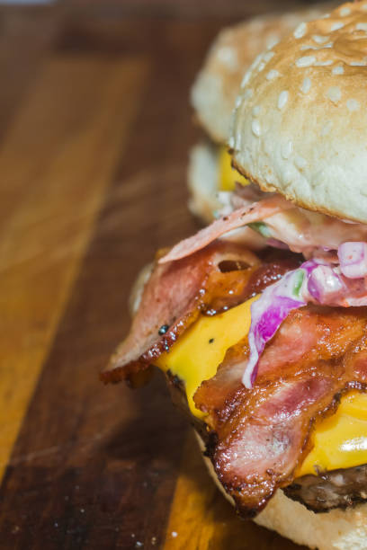hamburger with various exotic condiments, hand holding and copy space