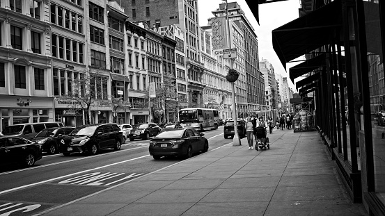 New York, NY, USA - Aug 7, 2021: Looking west along the sidewalk on 23rd Street as shown in black and white