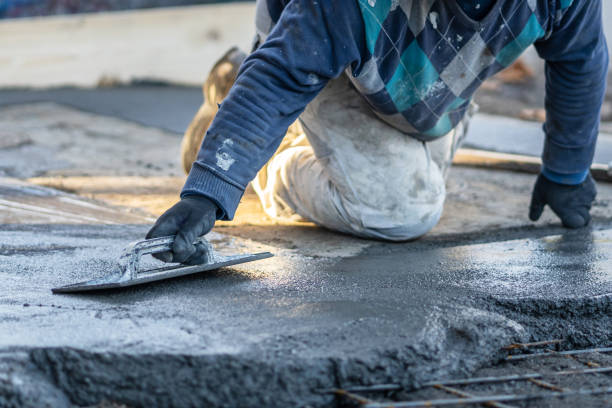 istock Close up on midsection of unknown worker spreading concrete cement mortar on the ground in day at construction site 1332910158