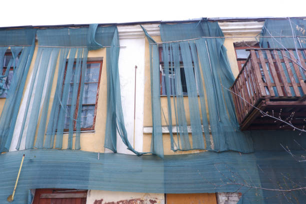 istock An old abandoned building covered with a rough cloth. Poverty and ruin concept. 1332910404