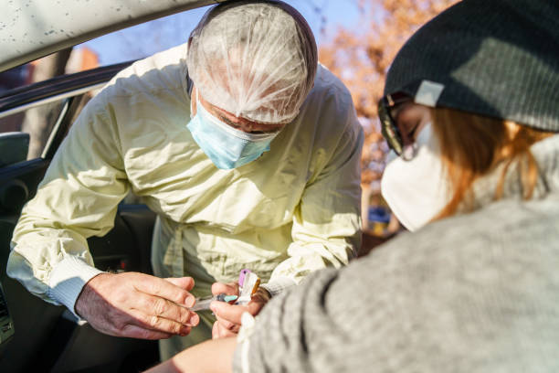 istock Medical technician wearing protective gear taking blood samples from patient sitting in the car for covid-19 coronavirus delta variant testing pandemic concept 1332911169