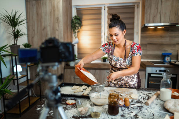 istock Woman filming vlog while kneading pastries at home in the kitchen 1332914316
