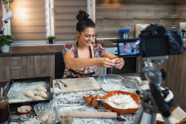 istock Woman filming vlog while kneading pastries at home in the kitchen 1332914911