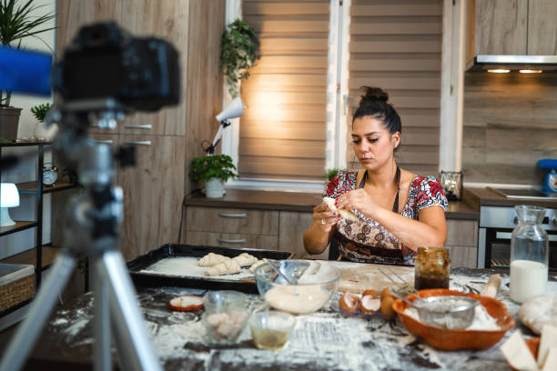 istock Woman filming vlog while kneading pastries at home in the kitchen 1332914930