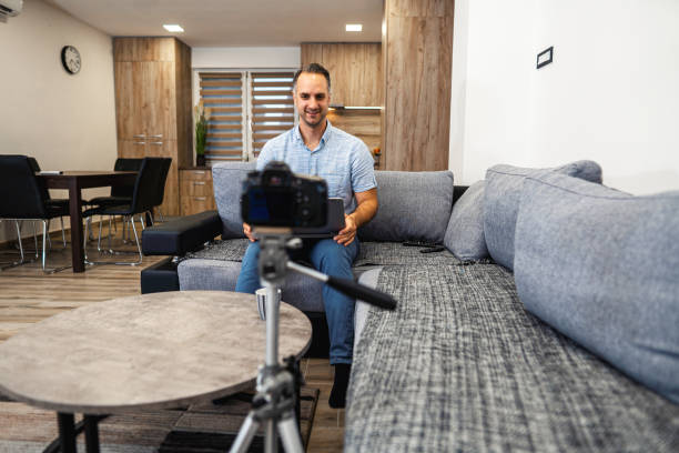 istock Young man making a video blog. Male vlogger recording content on digital camera. 1332915170