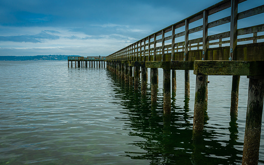 A horizontal oriented shot of a long wooden dock over the calm waters of Puget Sound
