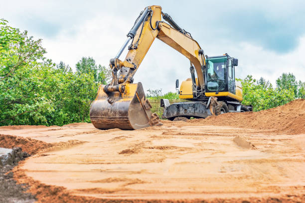 экскаватор выравнивает поверхность песка - earth mover digging land bulldozer стоковые фото и изображения