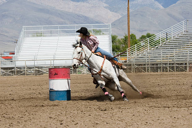 Carrera de caballos entre barriles Rodeo Cowgirl - foto de stock