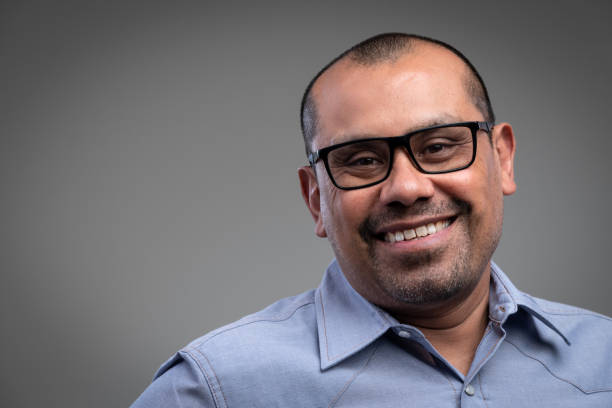istock Smiling mature hispanic man looking at the camera on gray background 1332931685