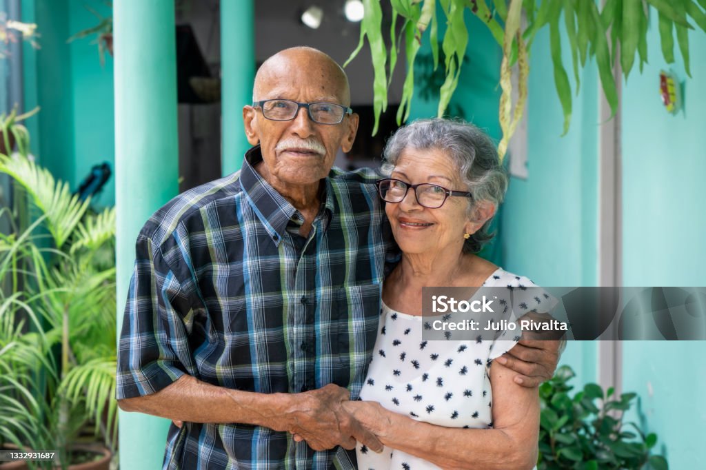 Elderly couple Elderly couple embracing and smiling looking at the camera Senior Adult Stock Photo