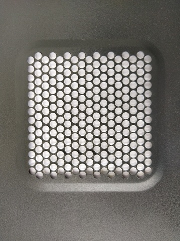 ventilation mesh of the computer. Metal surface with round numerous holes.