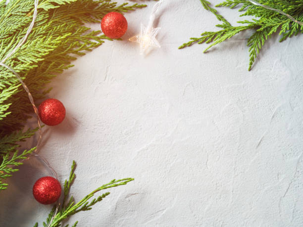 istock Green fir tree branches frame with star shape Christmas lights and red ornament decor 1332935531