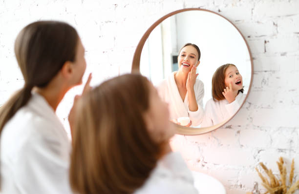 istock Mother and daughter applying cosmetic cream 1332938993