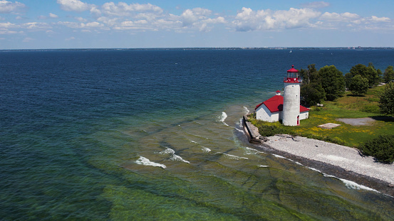 Aerial drone photograph of Nine Mile Point Lighthouse in Kingston Ontario Canada with Lake Ontario / St Lawrence River in the background