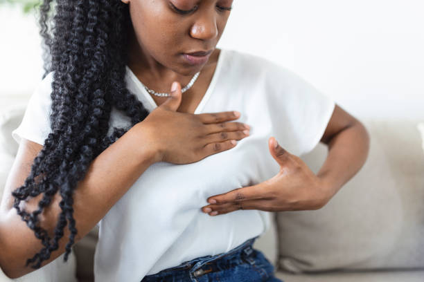 jovem afro-americana palpando seu peito sozinha que ela se preocupa com o câncer de mama. conceito de saúde e câncer de mama - breast sensuality women touching - fotografias e filmes do acervo