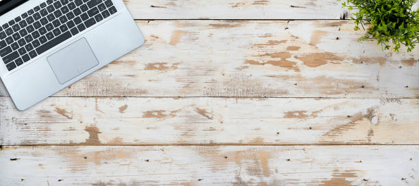 istock Wooden desk table top with tree pot on old wood 1332964602