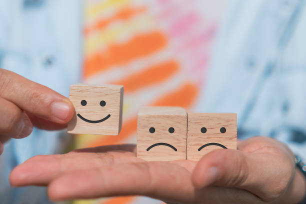 istock Smile face and cart icon on wood cube. Optimistic person or people feeling inside and service rating when shopping, satisfaction concept in business. 1332965249