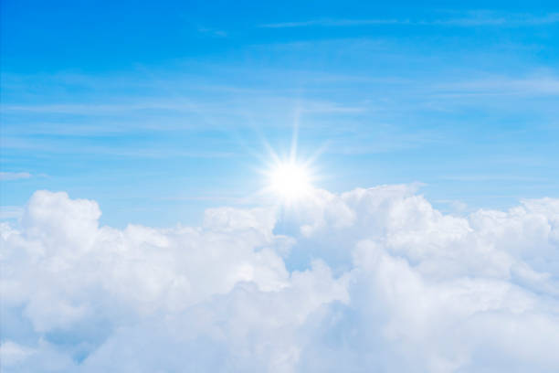 The sky is full of clouds floating around, both small and large, the sun is shining brightly