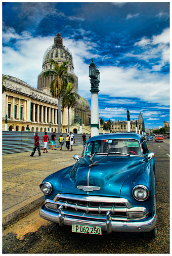 Havana, Cuba - April 20, 2014: Vintage cars in Cuba are part of daily life with most classic cars being used as taxis. Some of them look brand new, painted in vivid colors and transport tourists around. Those that are less well maintained are used as collective taxis or ‘taxi colectivos’ as Cubans call them. Other classic American cars are preserved like museum pieces.