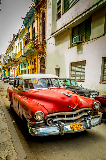 Havana, Cuba - April 19, 2014: Vintage cars in Cuba are part of daily life with most classic cars being used as taxis. Some of them look brand new, painted in vivid colors and transport tourists around. Those that are less well maintained are used as collective taxis or ‘taxi colectivos’ as Cubans call them. Other classic American cars are preserved like museum pieces.