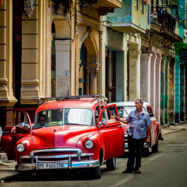 Havana, Cuba - April 20, 2014: Vintage cars in Cuba are part of daily life with most classic cars being used as taxis. Some of them look brand new, painted in vivid colors and transport tourists around. Those that are less well maintained are used as collective taxis or ‘taxi colectivos’ as Cubans call them. Other classic American cars are preserved like museum pieces.