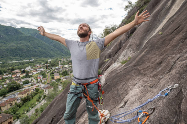 male mountain climber arms outstretched on mountain top - conquering adversity wilderness area aspirations achievement imagens e fotografias de stock