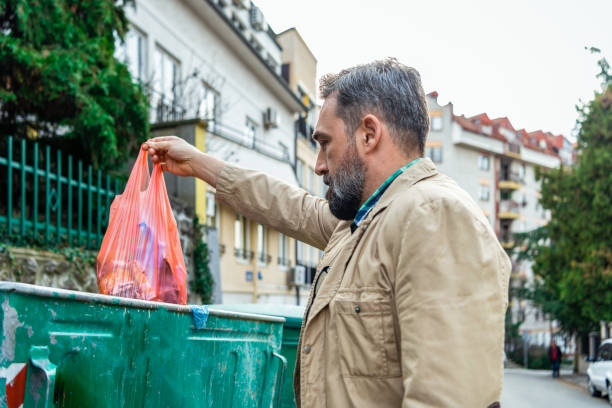 istock Mature man citizen throwing garbage in trash can, preventing littering, environment 1332969387