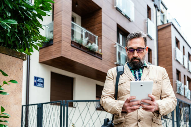 istock Fashionable Mature Man using reading glasses on digital tablet 1332969520