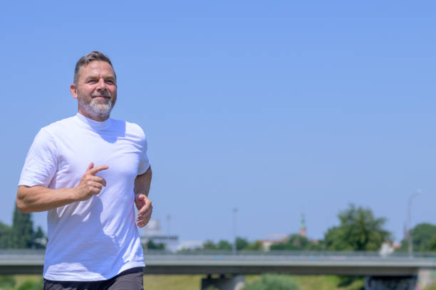 istock Senior man enjoying a jog outdoors in summer sunshine 1332970497