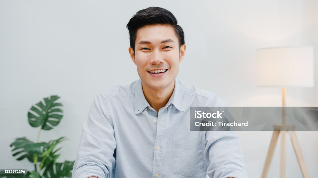 Portrait of successful handsome executive businessman smart casual wear looking at camera and smiling, happy in modern office workplace. Portrait of successful handsome executive businessman smart casual wear looking at camera and smiling, happy in modern office workplace. Young Asia guy talk to colleague in video call meeting at home. Men Stock Photo