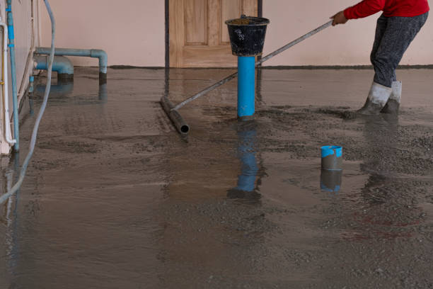 istock worker man working wet cement  on floor by use trowel with long Tools spreading poured concrete for strong street after dry. 1332978486