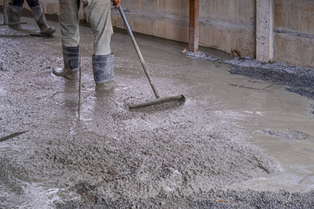istock worker man dirty working wet cement  on floor by use trowel with long Tools spreading poured concrete for strong street after dry. 1332978490
