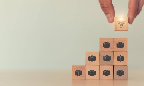 istock Online retail business development to enhance customer service with good experience; increase sales and business growth ; man holds cube with light icon symbol on many product boxes icon; copy space. 1332980940