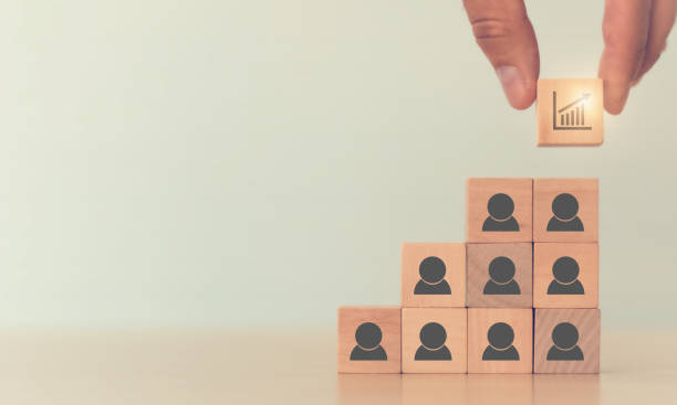 istock Up-skill concept to develop performance of human resources for business growth and digital transformation. Man holds wood cube with up-skill icon symbol on many staff icon symbol; copy space. 1332980942