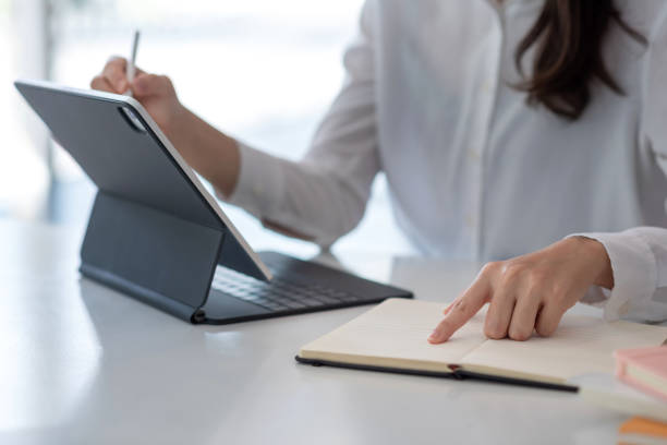 istock Image of a young woman pointing at a tablet document placed on an table office. 1332985398